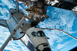 Backdropped by a blue and white Earth, Space Shuttle Endeavour, docked to the Destiny laboratory of the International Space Station